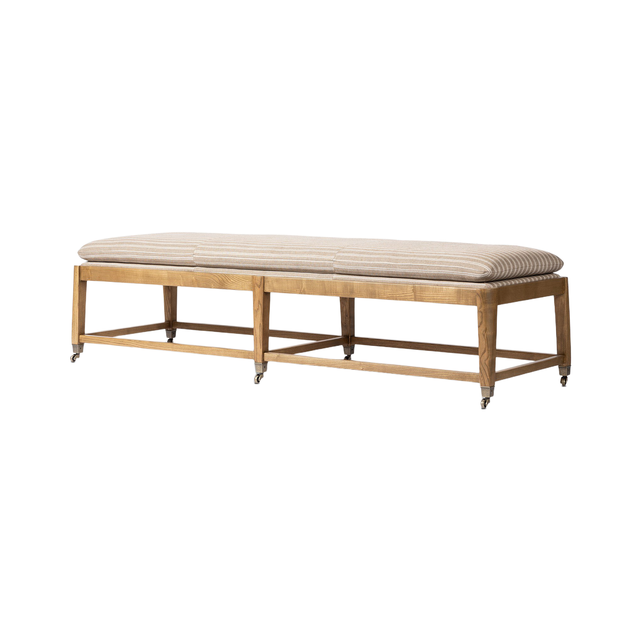 Angled view of the Serafina Bench highlighting its elongated striped cushion, warm wood frame, open base and small metal casters.
