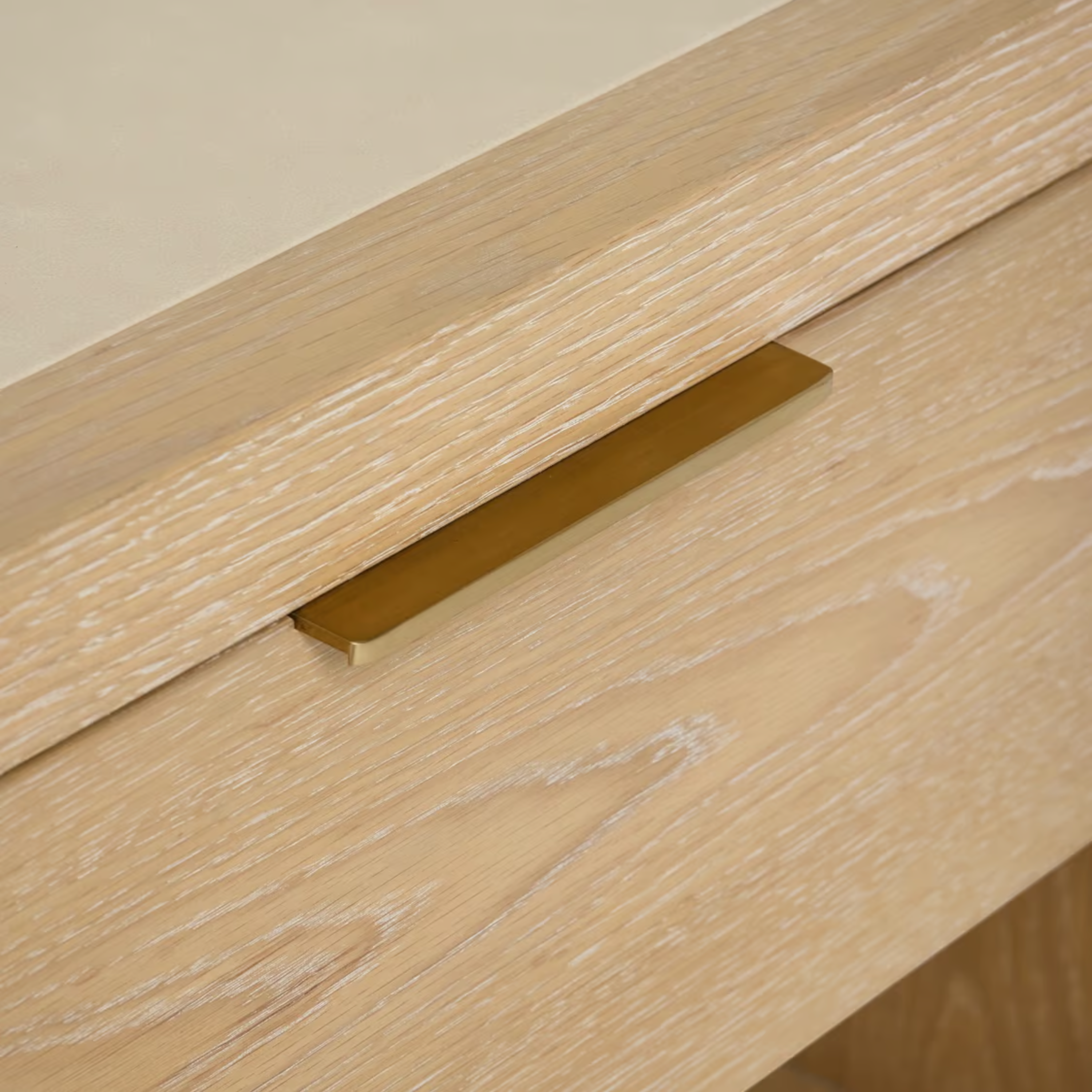 Close-up of Cleo Nightstand slim brass drawer pull and pale wood grain