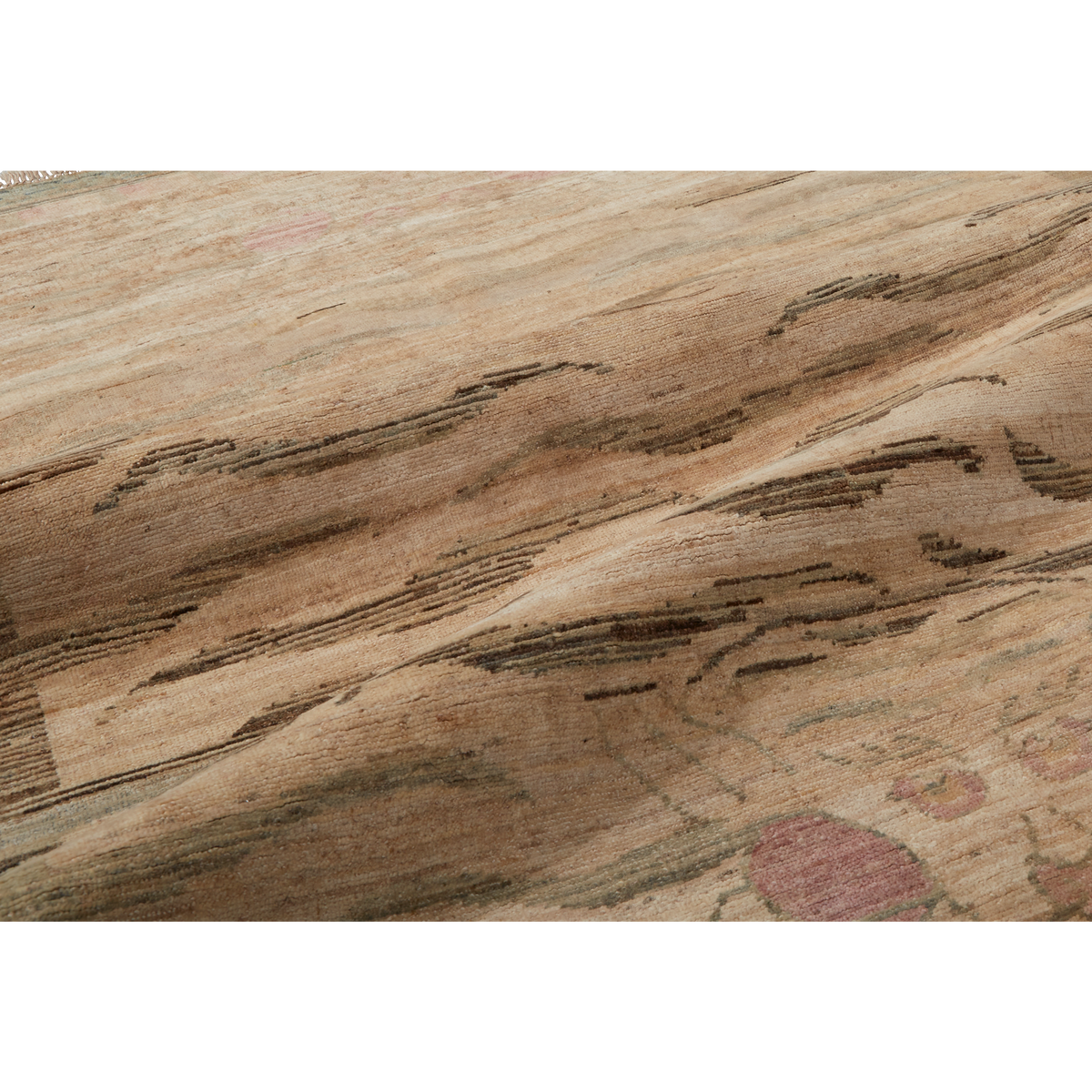A close-up of a textured rug or carpet showing a natural wood grain pattern in shades of beige, brown, and gray, with subtle pink accents.