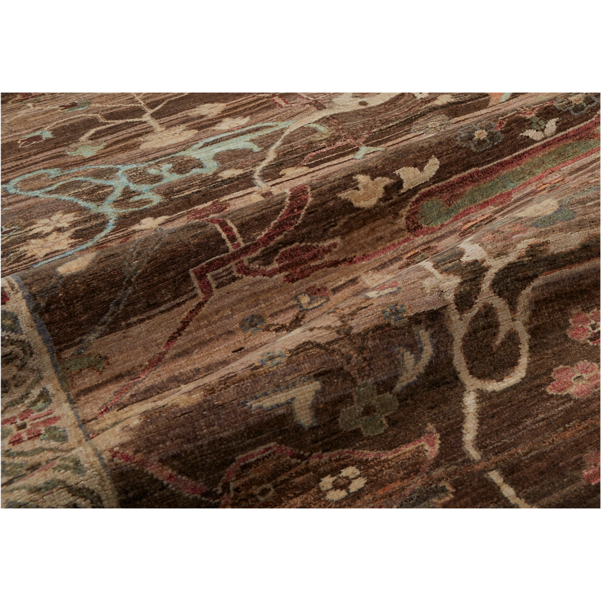 A close-up of a traditional patterned rug with a dark brown base and intricate floral and scroll motifs in beige, red, light blue, and muted green.