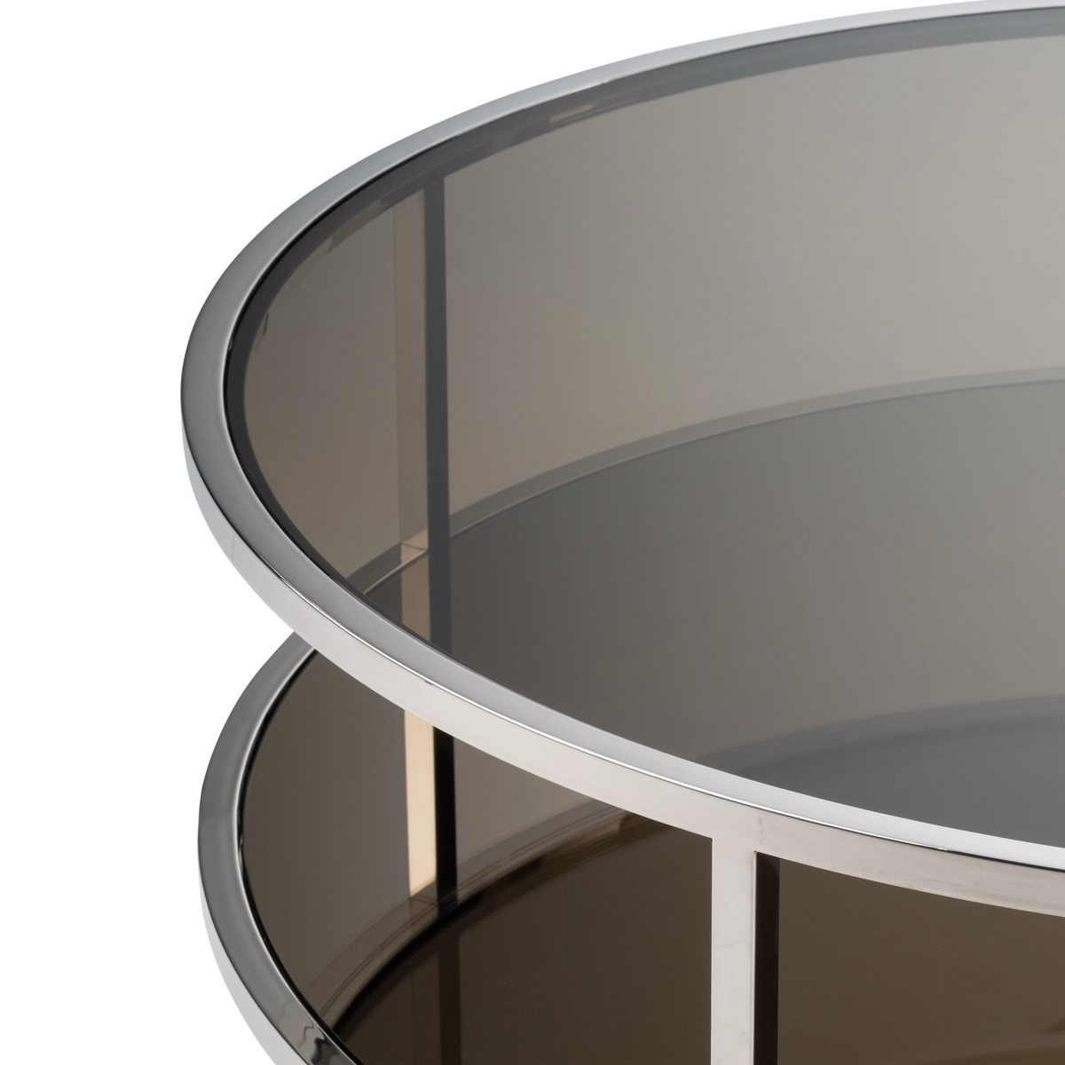 Close-up showing the Sandro Coffee Table’s polished steel ring around the smoked glass top, with the dark mirrored lower shelf and a square post visible below.