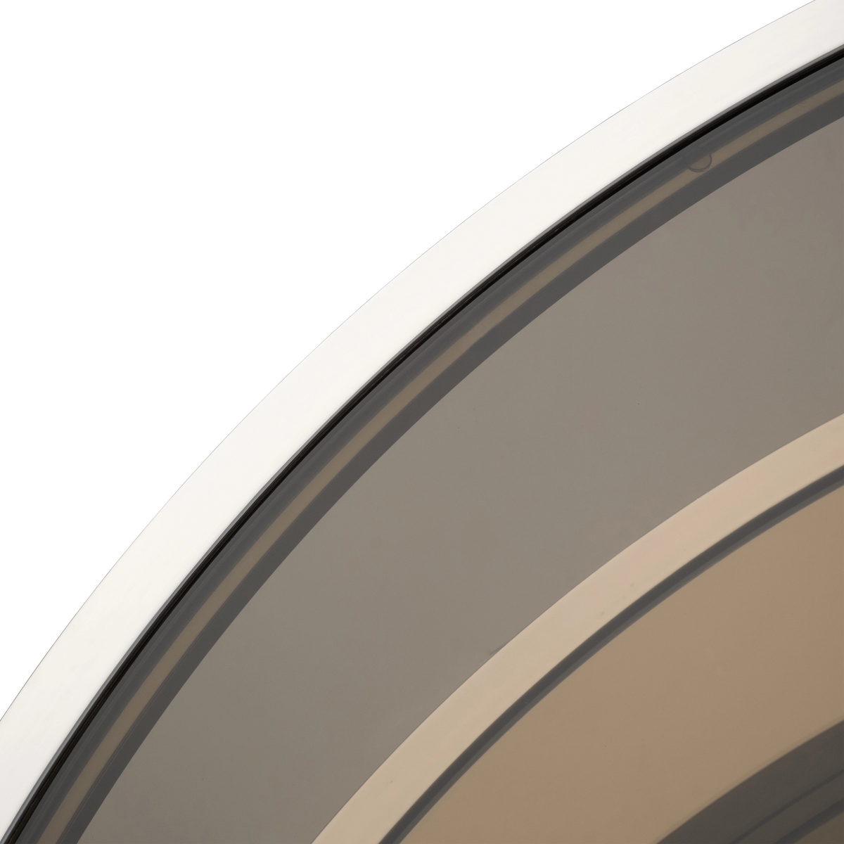 Close-up showing the Sandro Coffee Table’s mirror-polished steel rim framing the smoked glass, with warm brown reflections from the lower shelf.