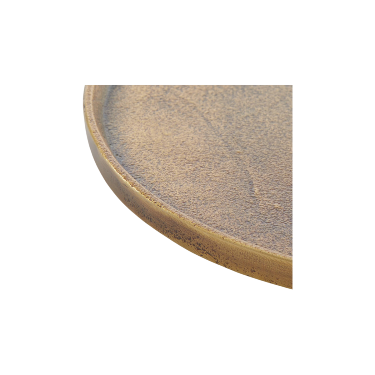 Close-up showing the rim of the Russell Tray Round Medium in antiqued brass, with a thin raised lip, a sand-like cast texture, and dark oxidized speckling along the outer edge.