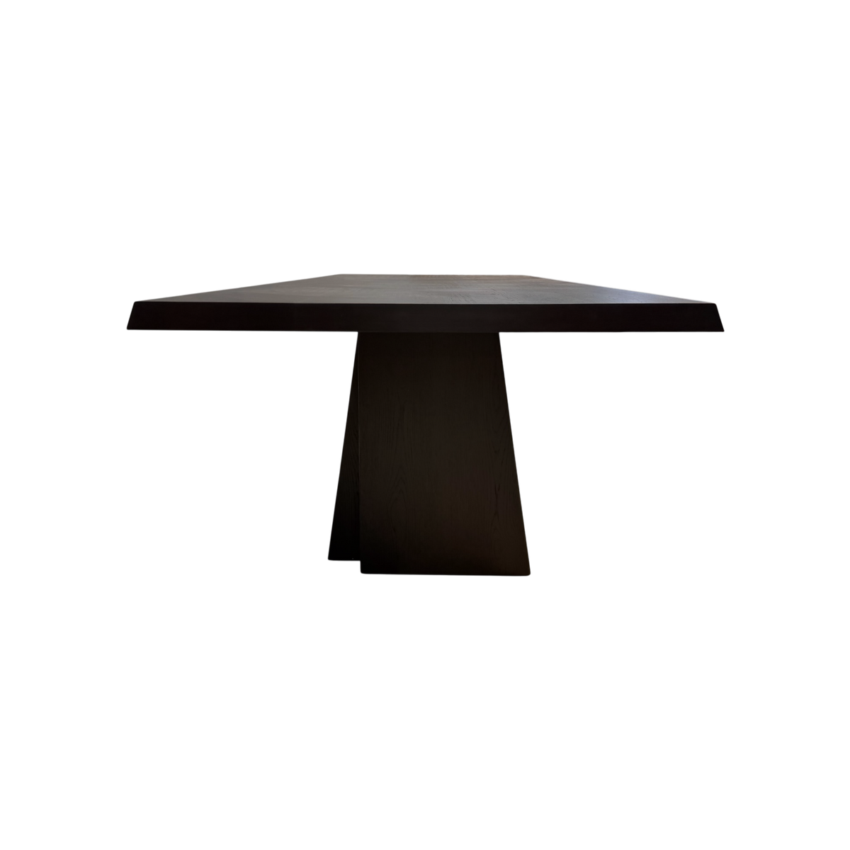 Angled view of the Oblique 120-inch Dining Table showing its elongated dark wood top, chamfered edges and sculptural splayed pedestal bases.