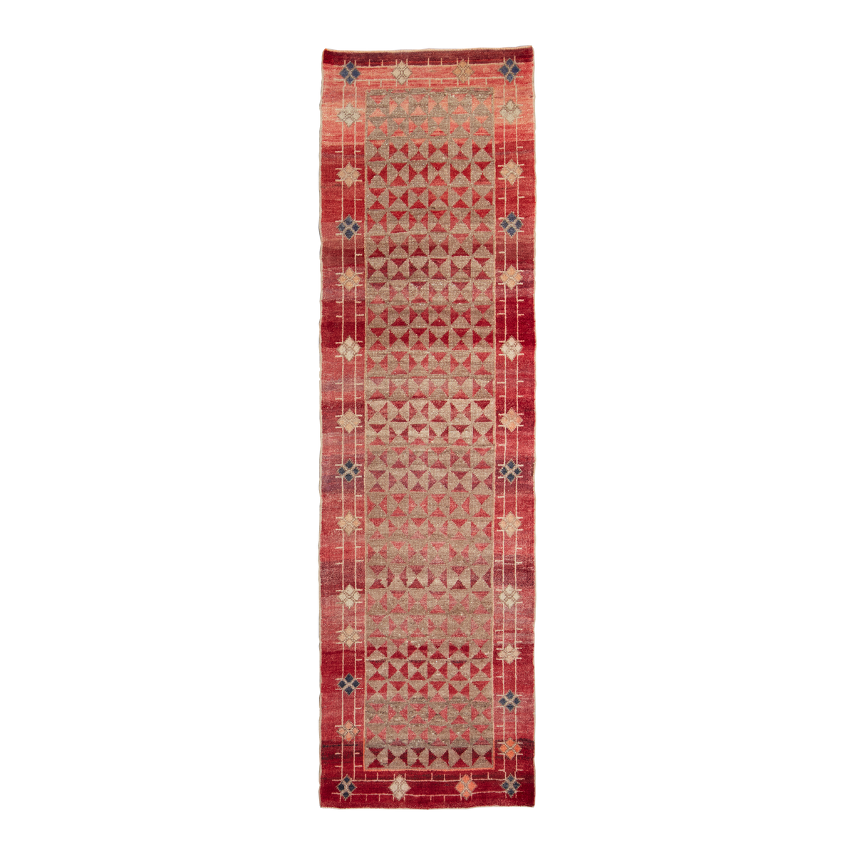 A long rectangular area rug with a traditional geometric pattern in shades of red, beige, and muted blue, shown flat against a solid white background.