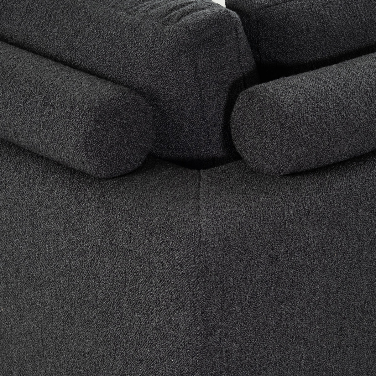 Close-up of the Colonna Modular Sectional in charcoal bouclé showing two bolsters resting against the back cushion above a single center seam.
