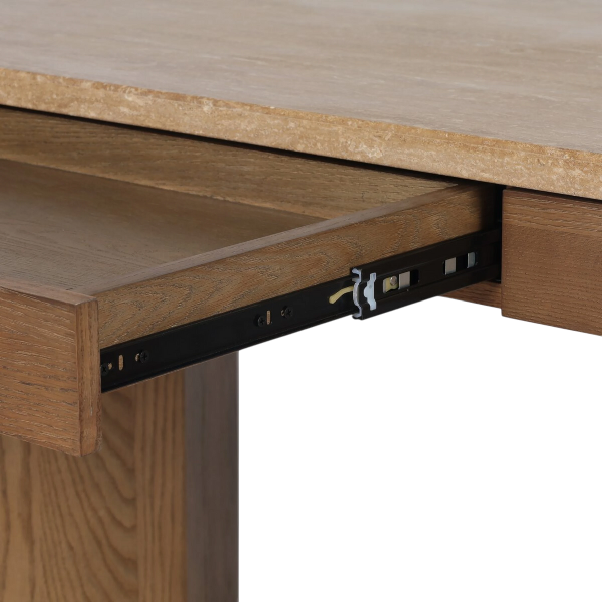 Detail of an open Cobble Desk drawer showing the oak interior, concealed metal glides and travertine top above.