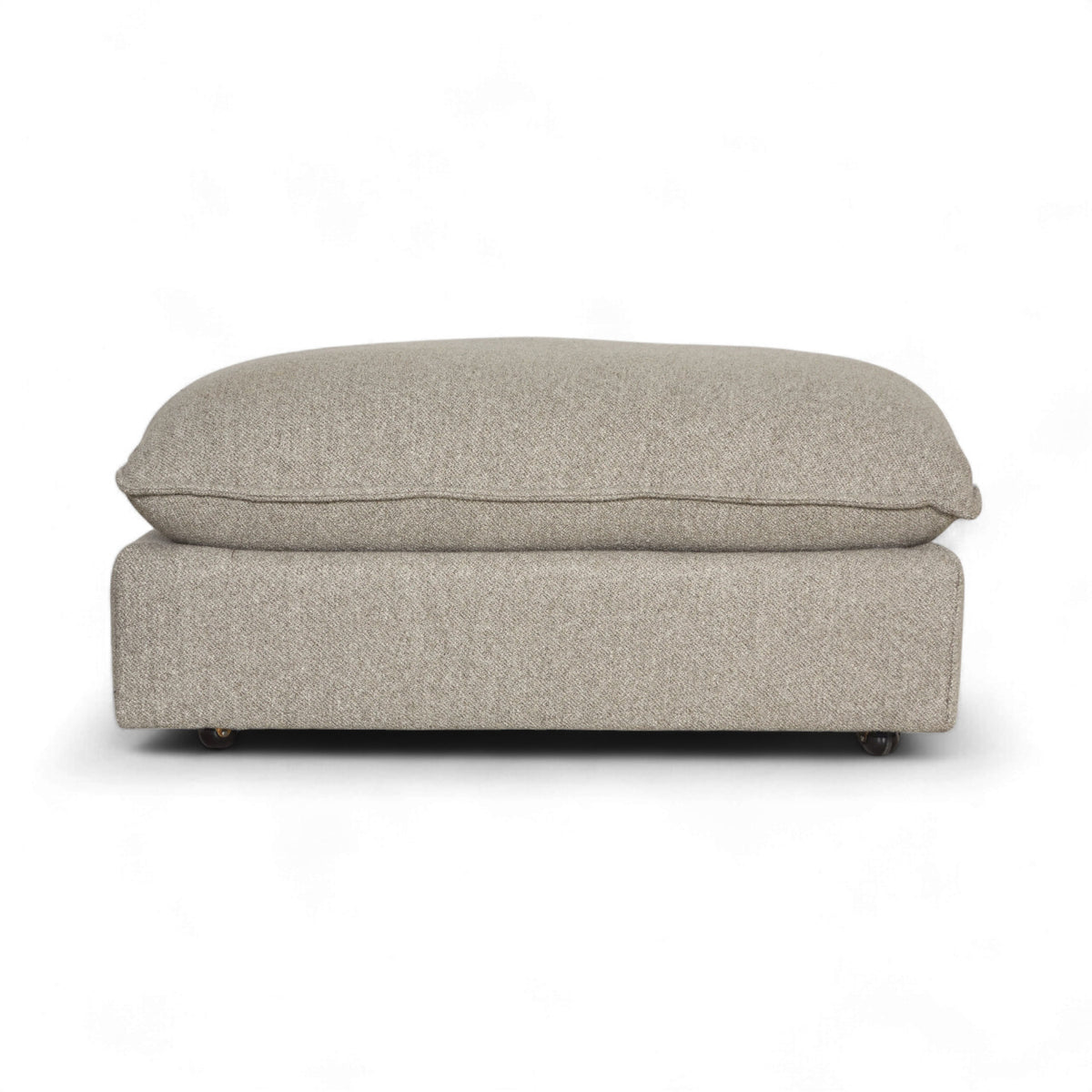 Byers Modular Sectional ottoman in warm gray heathered fabric, viewed head-on with a plush flanged top cushion, low upholstered base, and small casters.