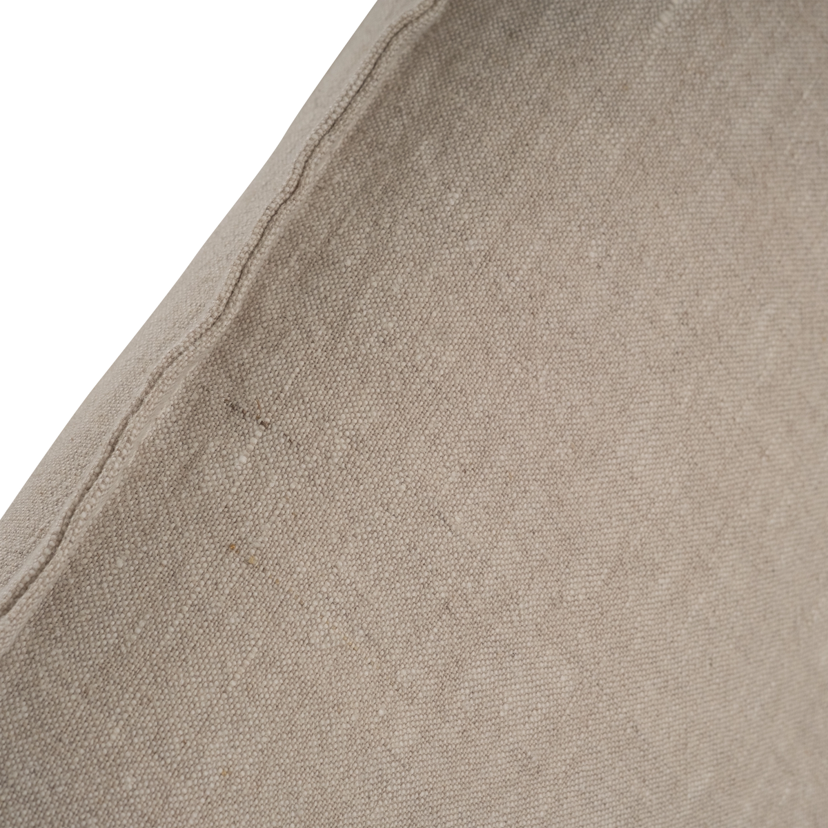Detail of the Muse Queen Bed's natural linen slipcover, showing the visible weave and a finished seam along the headboard edge.