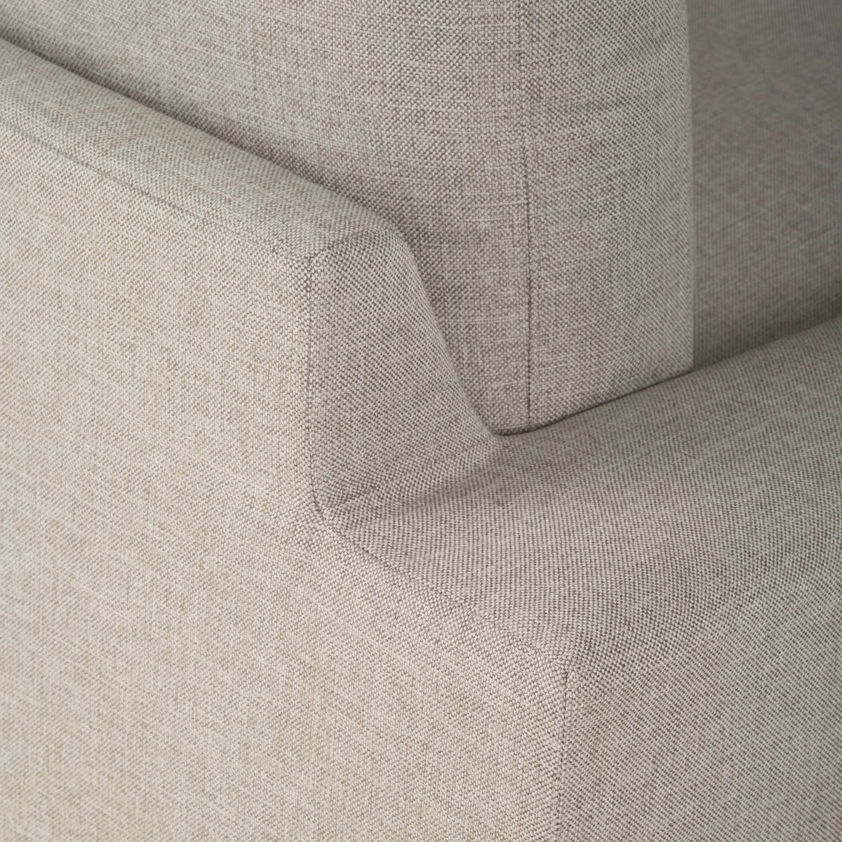 Montara Sofa in Pumice woven fabric shown in close-up where the arm meets the back cushion, with a stitched seam and a crisp, squared corner.