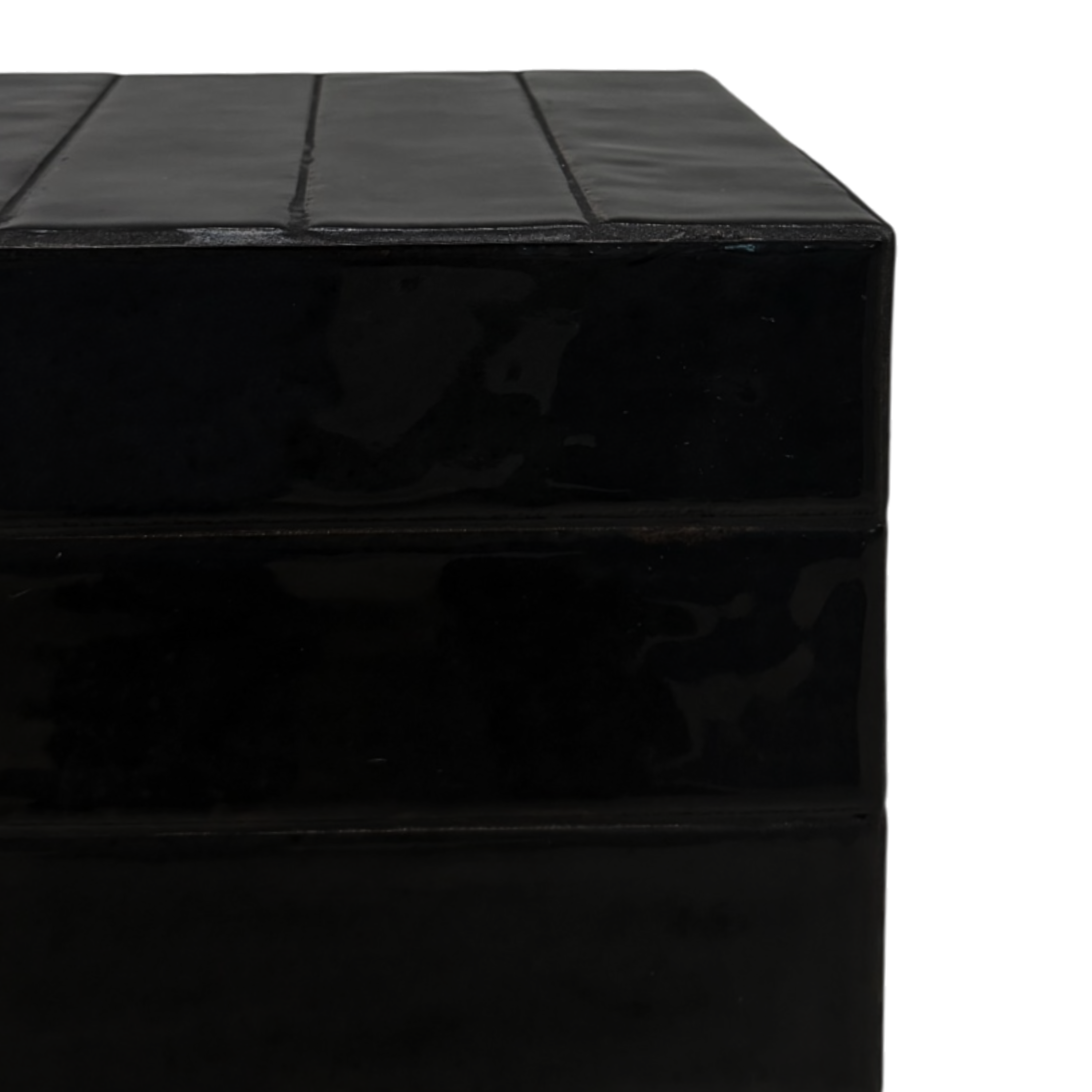 Close-up of the Bloor Side Table, showing its subtly reflective black finish, horizontal seams and segmented top detailing