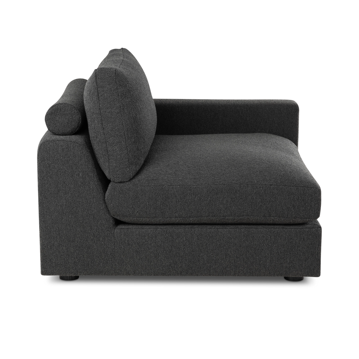 Side profile of the Colonna Modular RAF Chair in charcoal bouclé, showing the slim cylindrical bolster, the angled back cushion with its stitched edge, and the tall low-set arm.