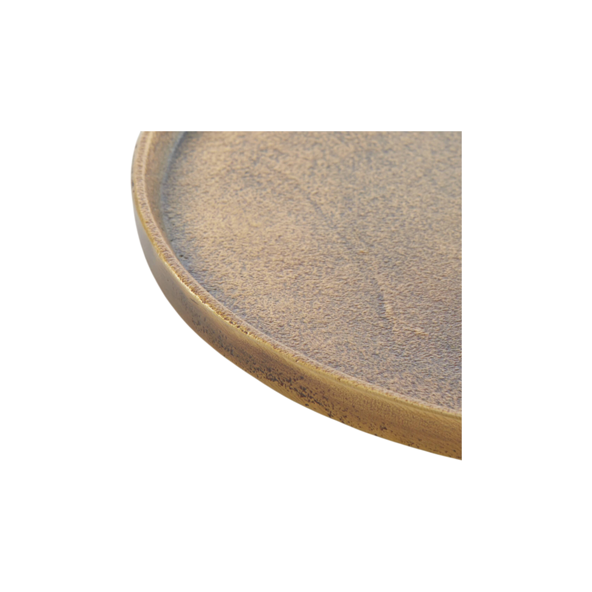 Close-up showing the rim of the Russell Tray Round Small in antiqued brass, with a thin raised lip, a sand-like cast texture, and dark oxidized speckling along the outer edge.