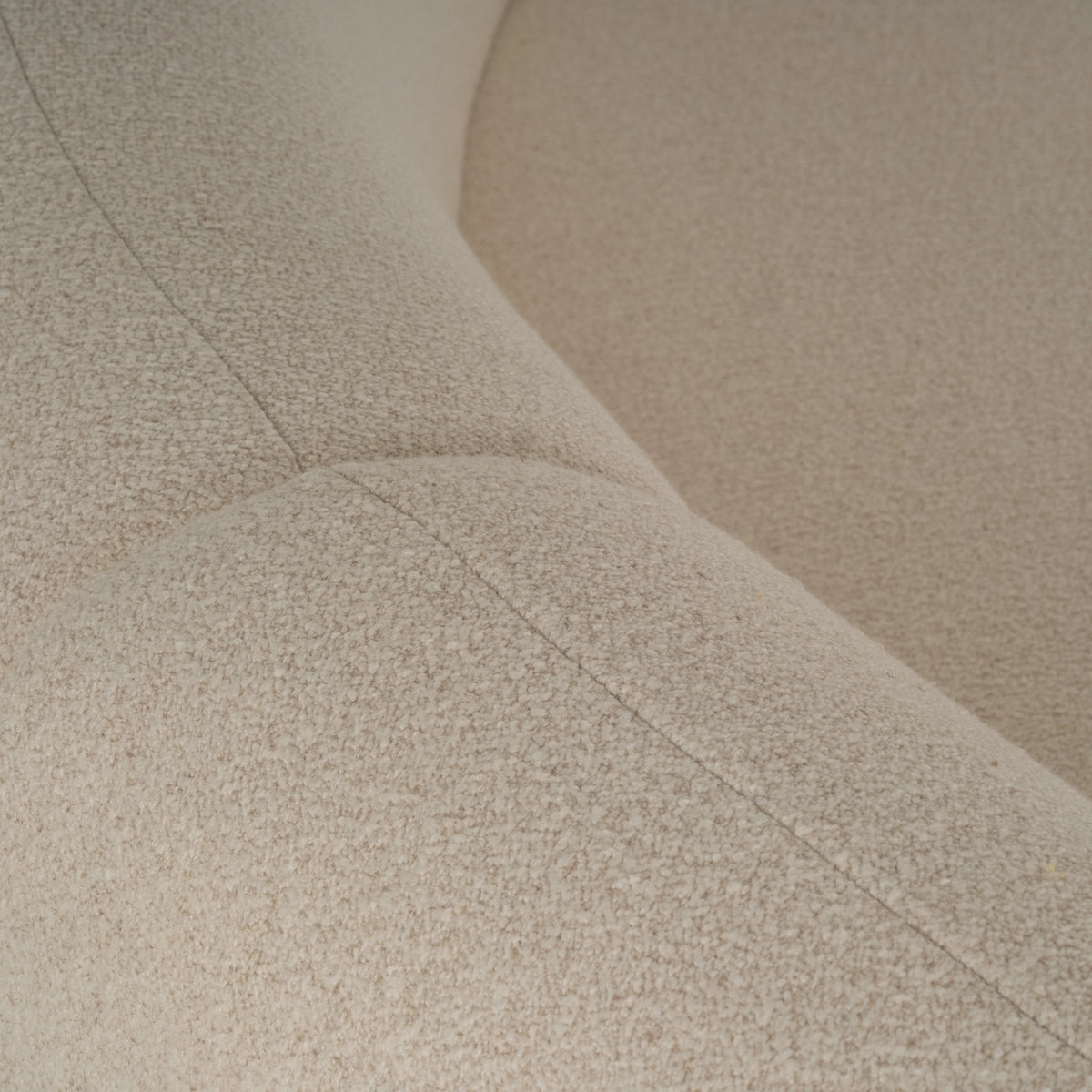 Rhine Modular Sectional Sofa in cream bouclé shown close up along the arm, with the fine seam stitching and the nubby oatmeal-flecked texture clearly visible.