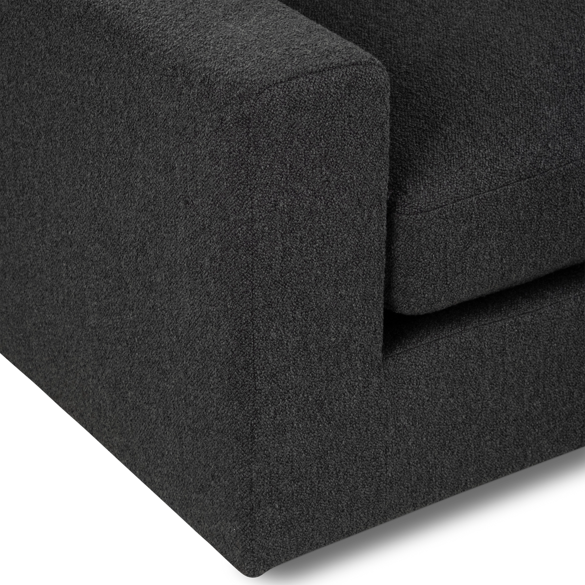 Detail view of the Colonna Modular Sectional in charcoal bouclé, highlighting the squared arm corner, the seat cushion edge, and the clean seam along the base.
